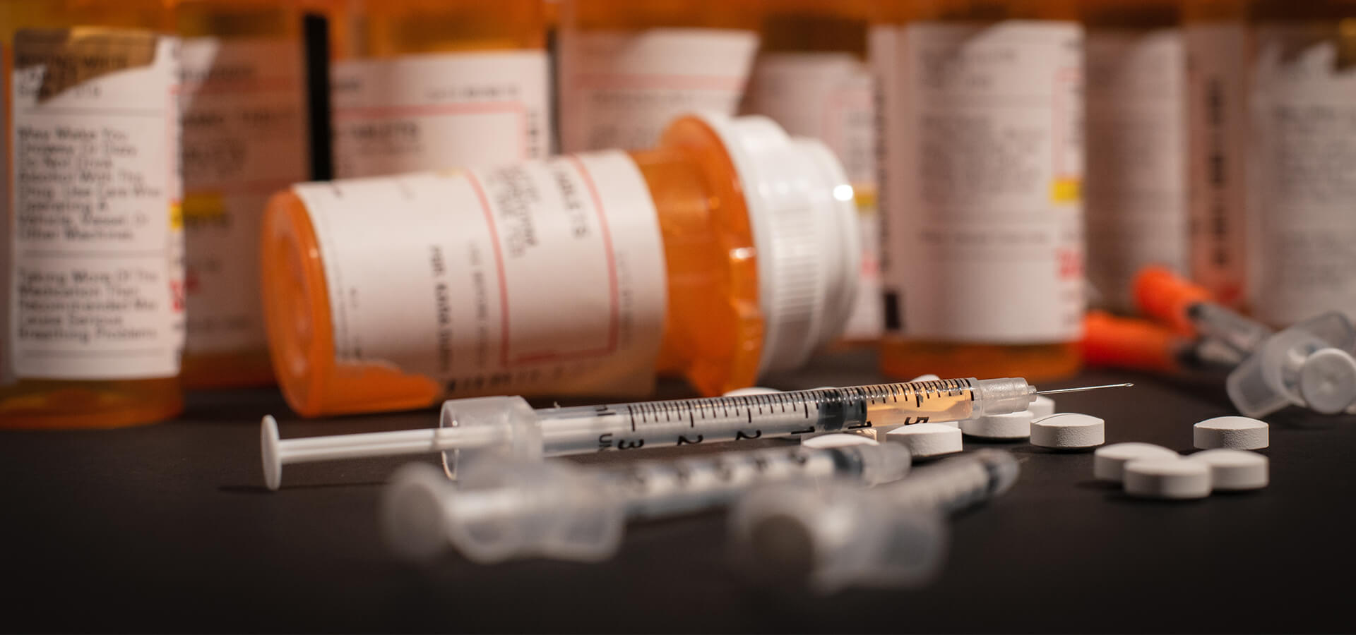prescription drug pills and hypodermic needle
