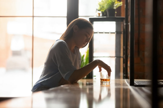 a woman drinking but struggling with physical dependence
