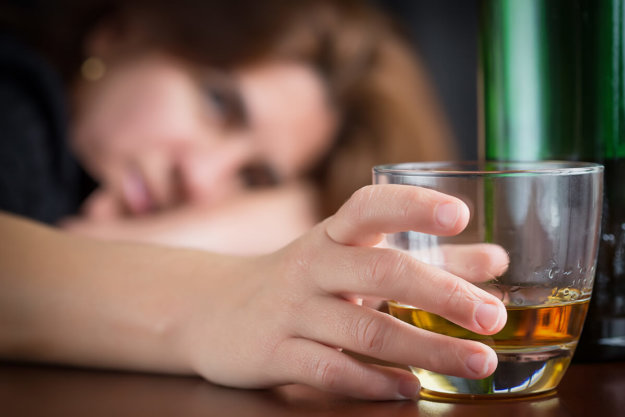 a woman drinking while showing Signs of Addiction