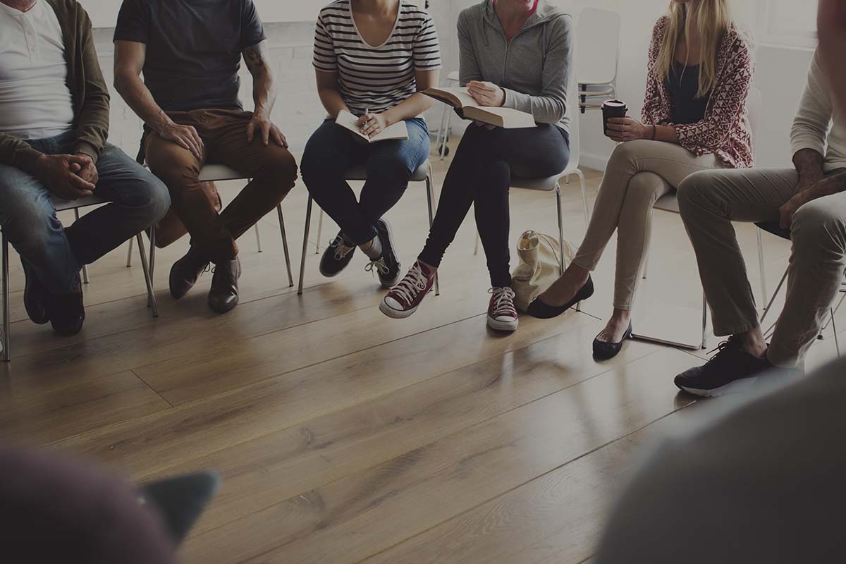 People sitting in a circle counseling individuals in support groups